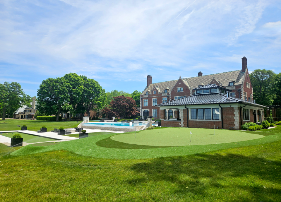 Backyard putting green with pool and bocce court